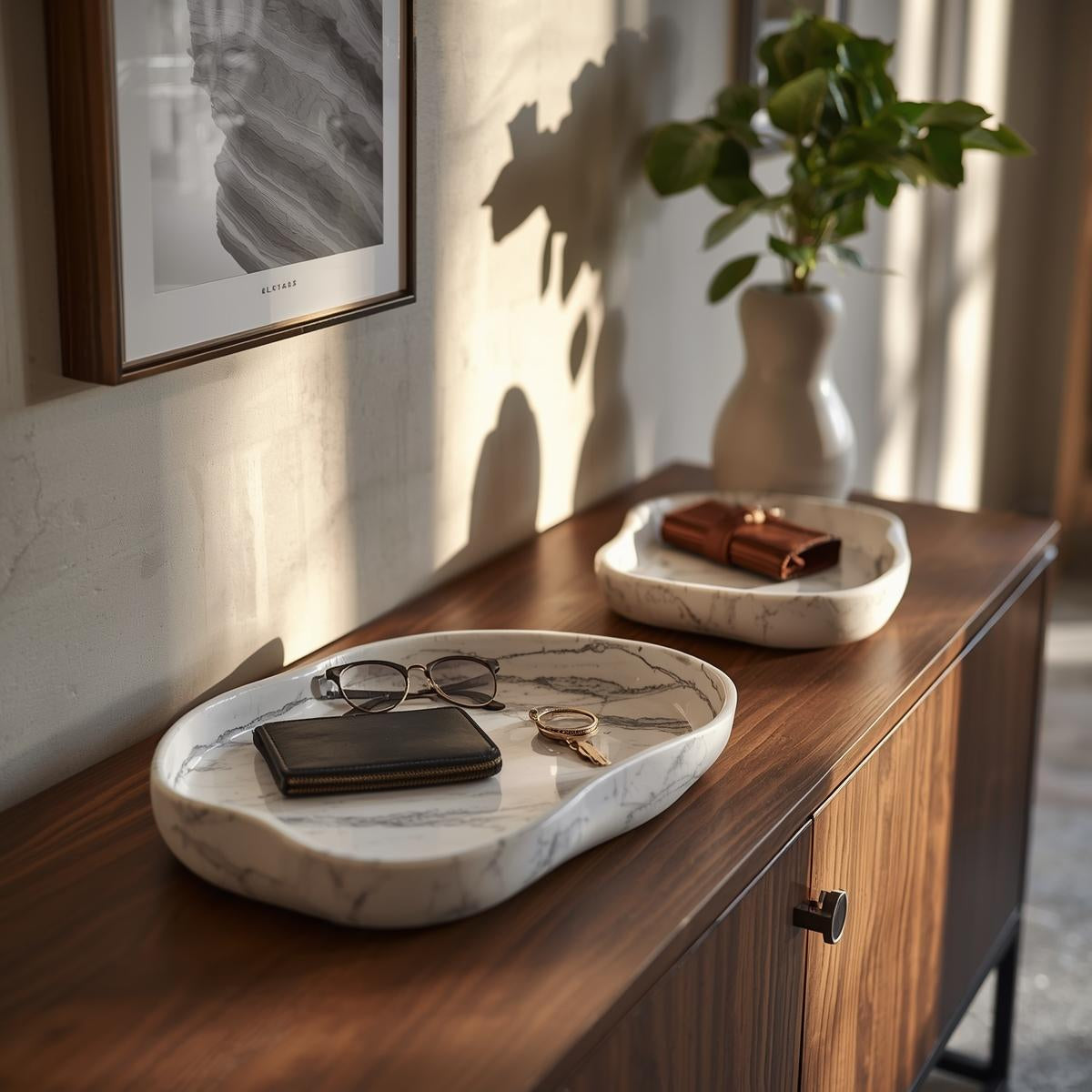 Minimal marble-style catchall tray holding keys and small essentials on an entryway console table in warm natural daylight.